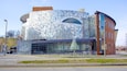 A building with a mosaic facade and a large glass entrance.