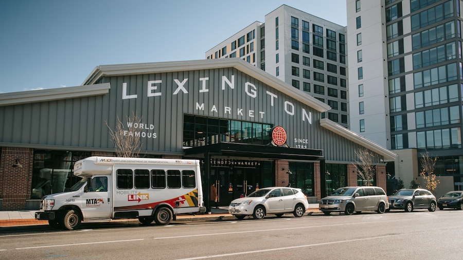 Lexington Market with a white bus and cars parked in front.