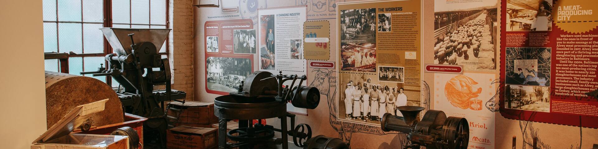 A historical exhibit on meat processing in Baltimore, featuring vintage machinery and informational posters.