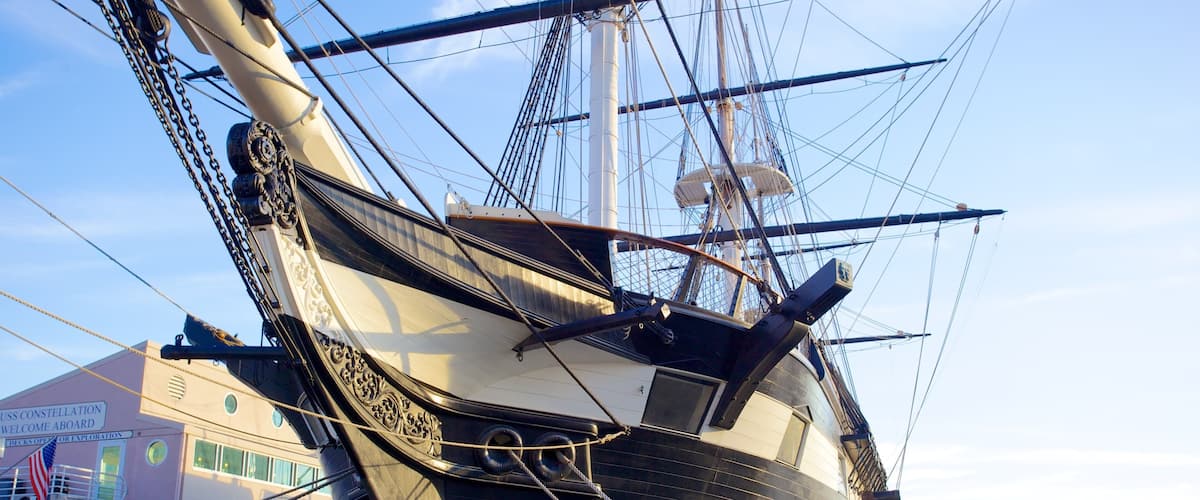 USS Constellation docked in Baltimore's Inner Harbor at sunset, showcasing its historical maritime significance