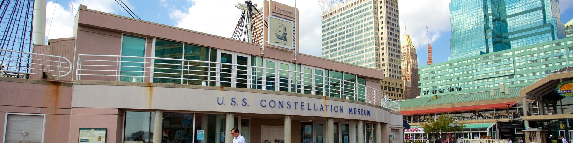 USS Constellation mostrando un edificio alto y una ciudad y también un hombre