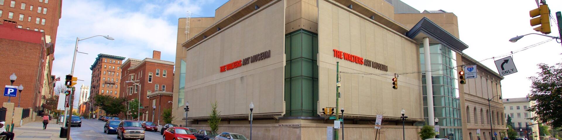The Walters Art Museum with a modern facade, located at a busy intersection with cars and pedestrians.