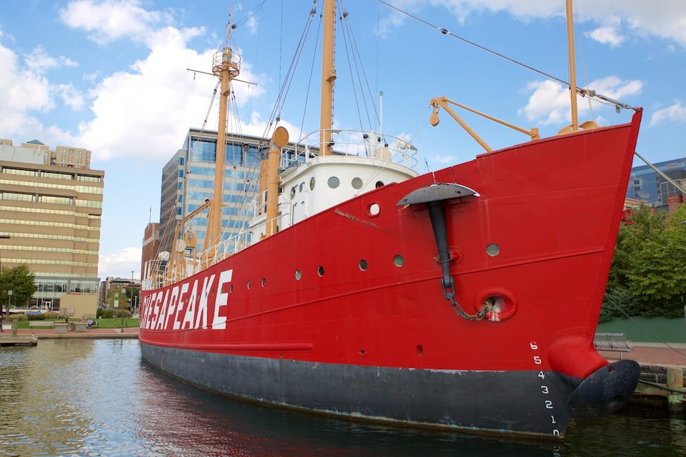 Un navire rouge, baptisé «
CHESAPEAKE
», accosta dans un port où se dressaient des bâtiments, avec un ciel dégagé en arrière-plan.