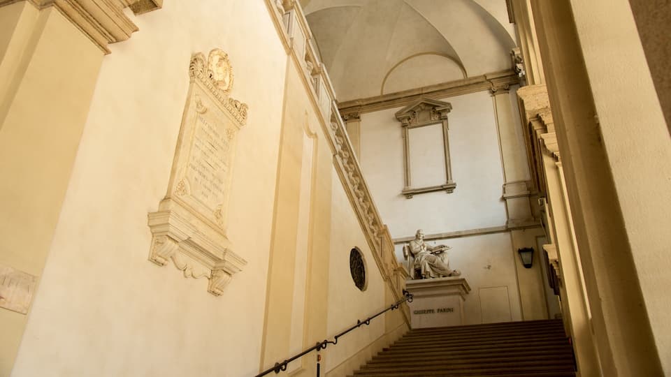 Un'imponente scalinata con una statua di una figura seduta alla base.