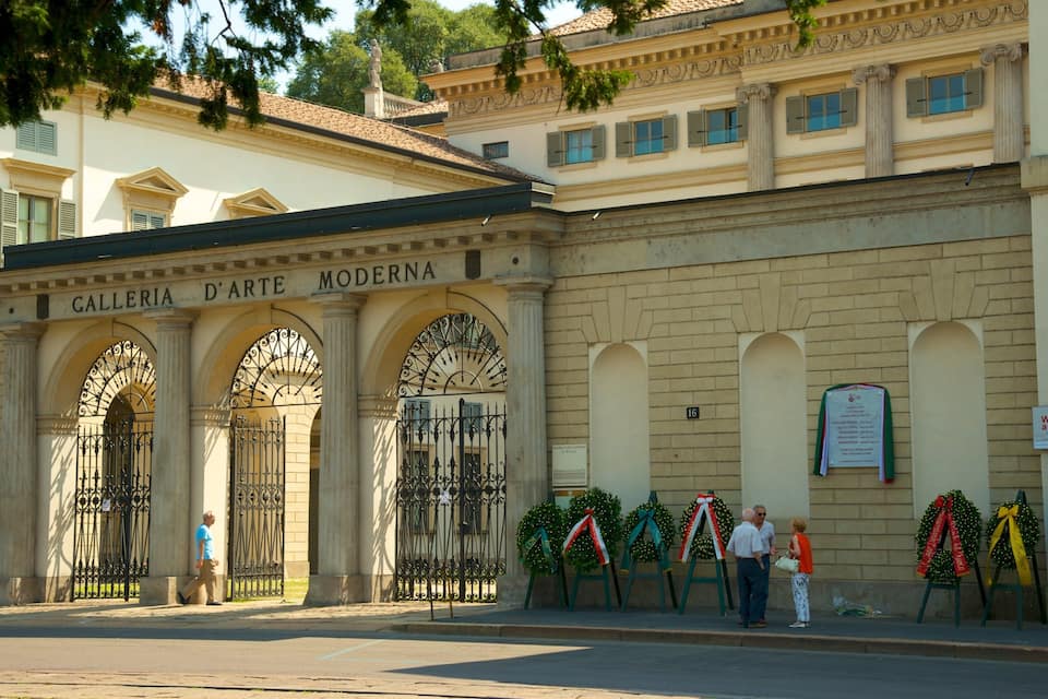 Exterior da galeria de arte moderna, com portões de ferro ornamentados e guirlandas de Natal.