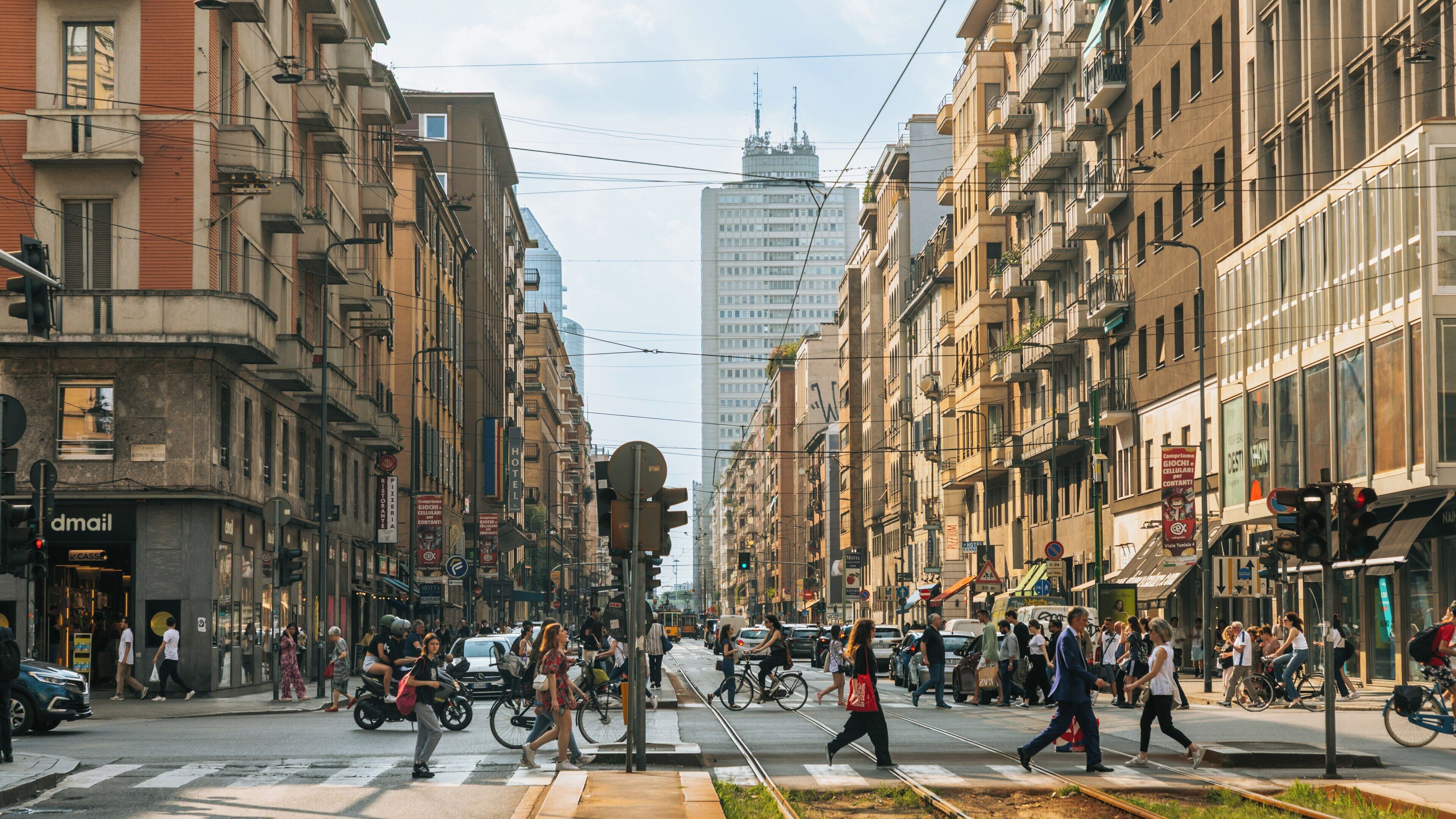 Bustling crosswalk at Porta Venezia in Milan showcases vibrant urban life and city architecture in Lombardy, Italy during a sunny day