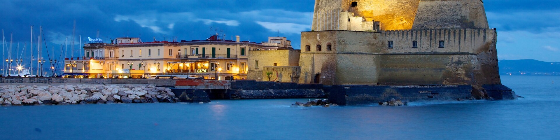 Castel dell\'Ovo caracterizando cenas noturnas, paisagens litorâneas e arquitetura de patrimônio
