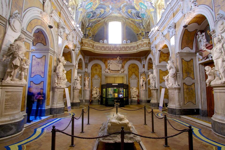 Ein prächtiges Kircheninnere mit Marmorstatuen und einem zentralen Altar.