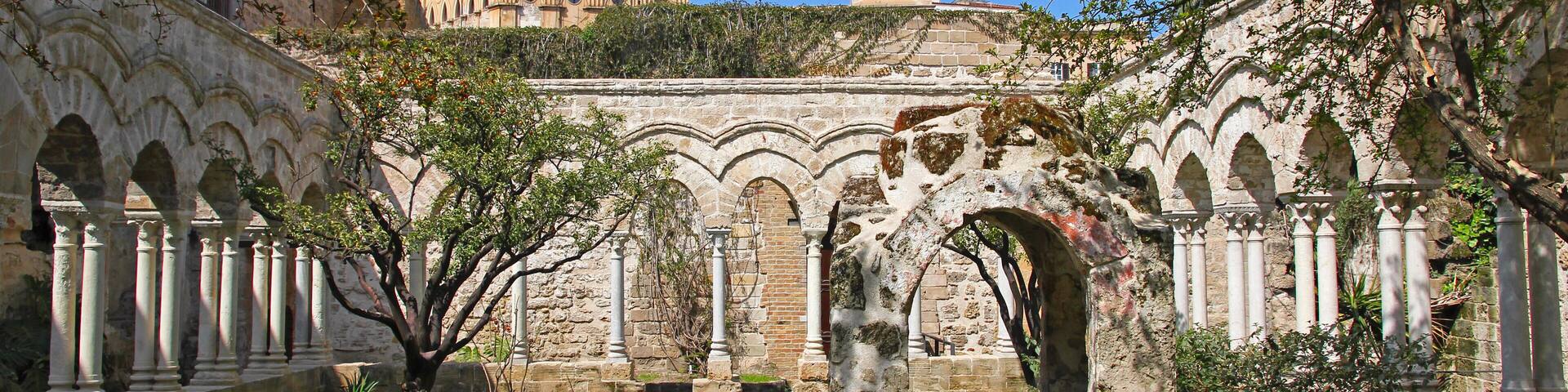 An ancient stone pathway leading to a historic building with arches and columns.