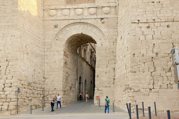 Arco Etrusco featuring heritage architecture as well as a small group of people