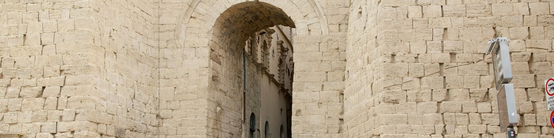 Arco Etrusco caracterizando arquitetura de patrimônio assim como um pequeno grupo de pessoas