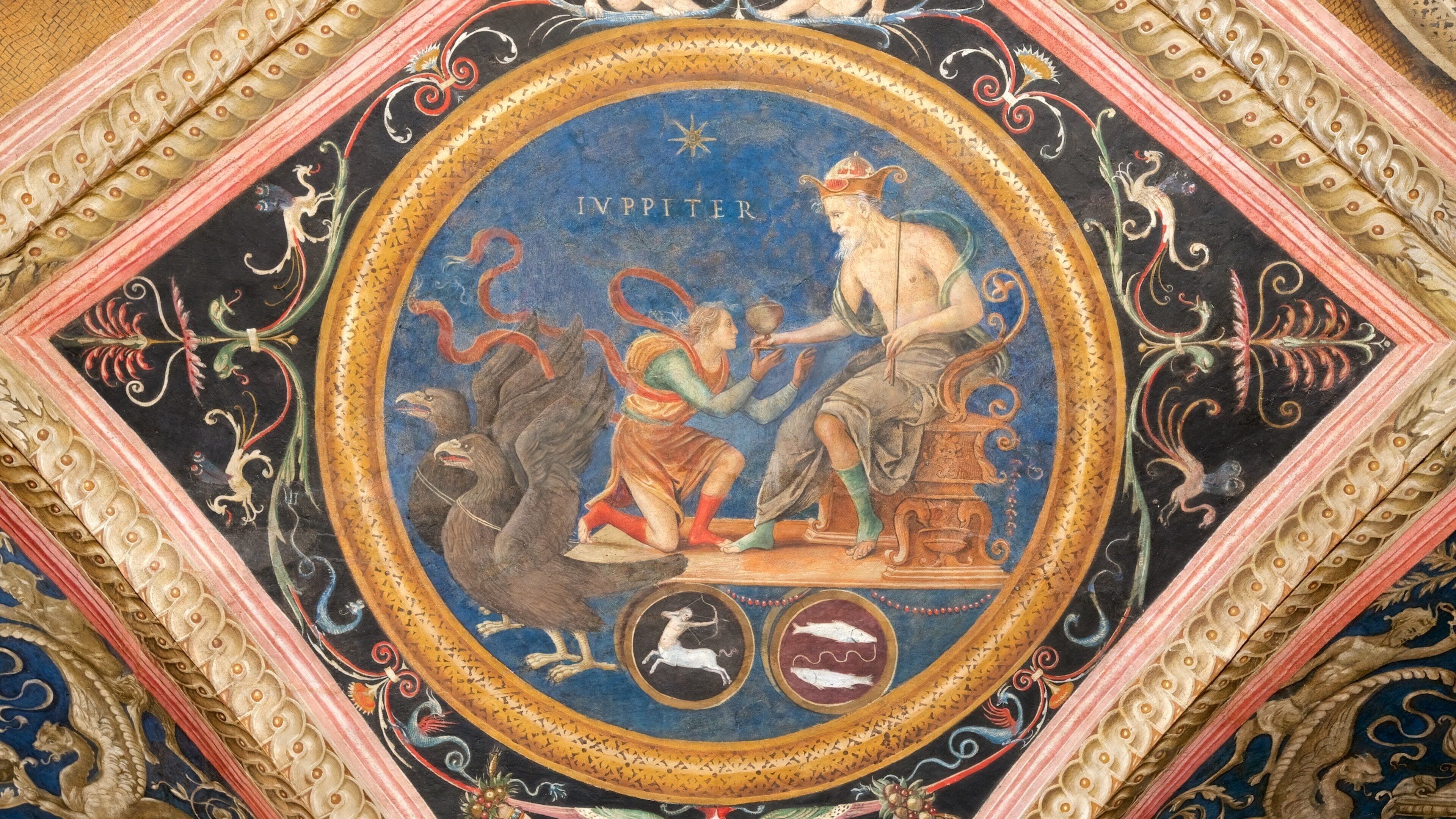 Un fresco detallado con un motivo circular central, que presenta una figura con la inscripción 'IVPPITER' y diversas criaturas mitológicas.