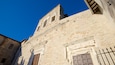 Un edificio storico con finestre ad arco e elaborate decorazioni in pietra.