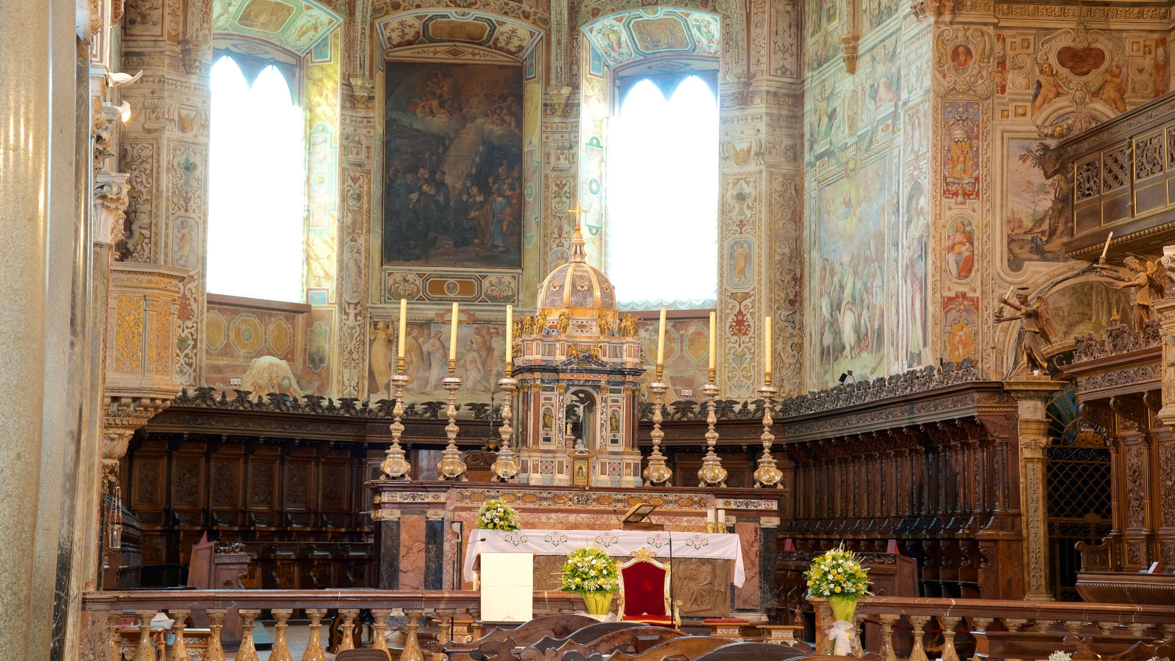 Interno di una chiesa decorata con un altare centrale, ampie affresche e elaborate decorazioni in legno.