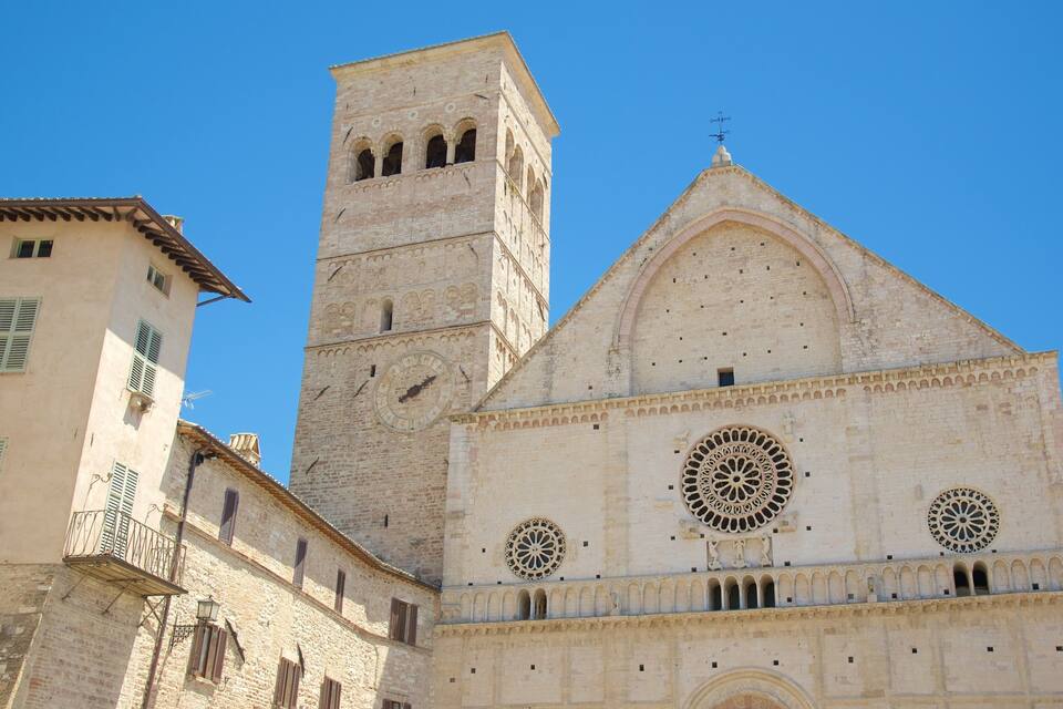 A historic cathedral with a prominent clock tower and intricate rose window designs.
