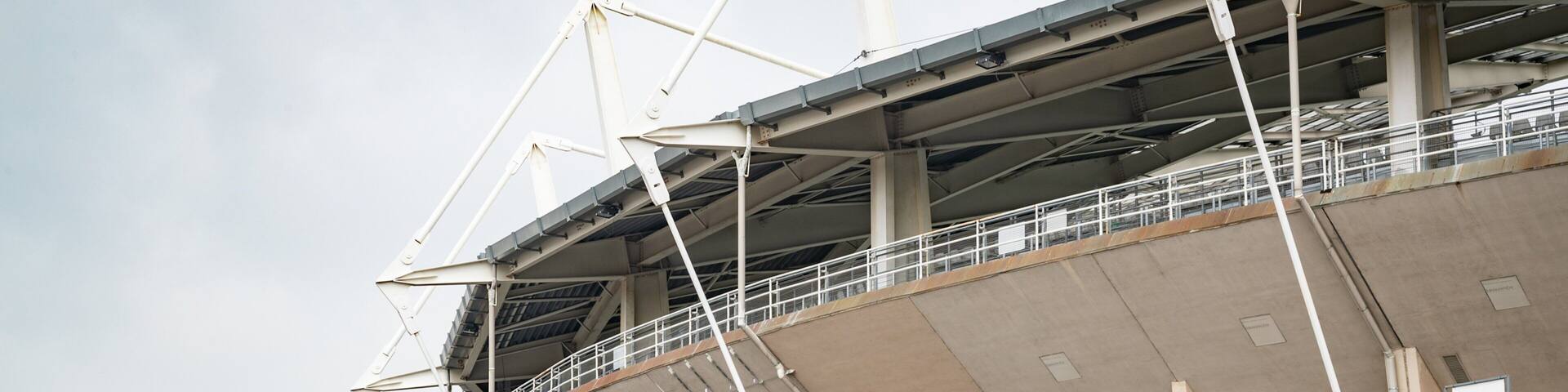 A stadium with a large roof structure and multiple levels of seating.