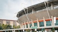 Un estadio con una amplia estructura de techo y varios niveles de gradas.