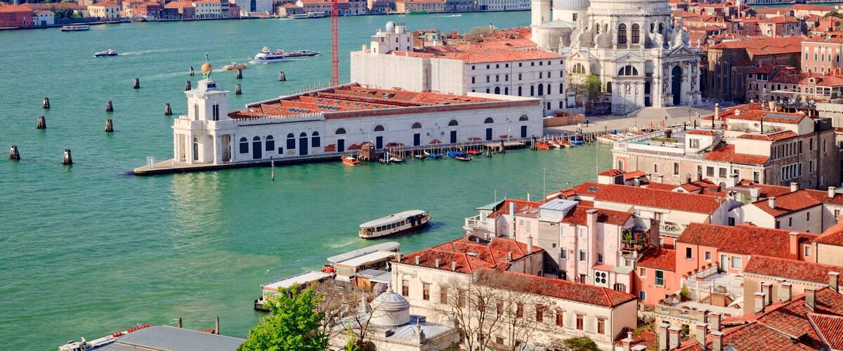A panoramic view of Venice's Grand Canal with historic buildings and gondolas.