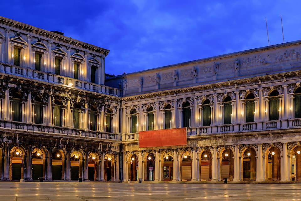 Un edificio histórico con arquitectura clásica, que presenta columnas, arcos y esculturas detalladas.