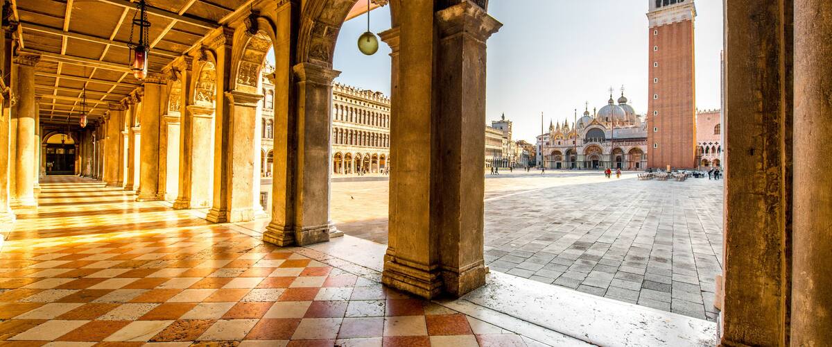 Arches of Correr museum with San Marco tower on the main square in the morning in Venice