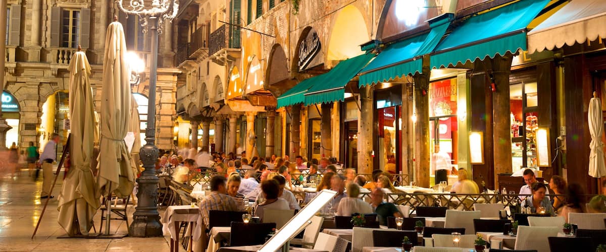 Piazza delle Erbe ofreciendo comer al aire libre, escenas nocturnas y un parque o plaza