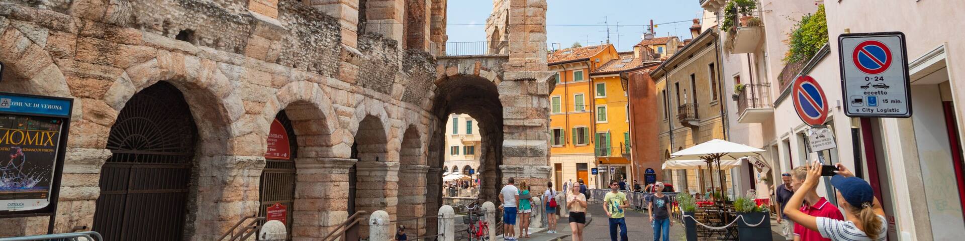 An ancient stone archway with a tall tower in the background.