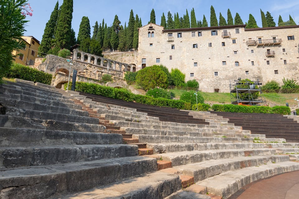 Stone steps leading up to a historic building with a stone facade and multiple windows.