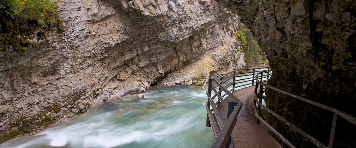 Johnston Canyon featuring a river or creek, rapids and landscape views