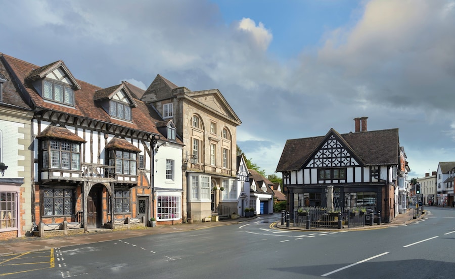 A street with historic half-timbered buildings and a clear sky.