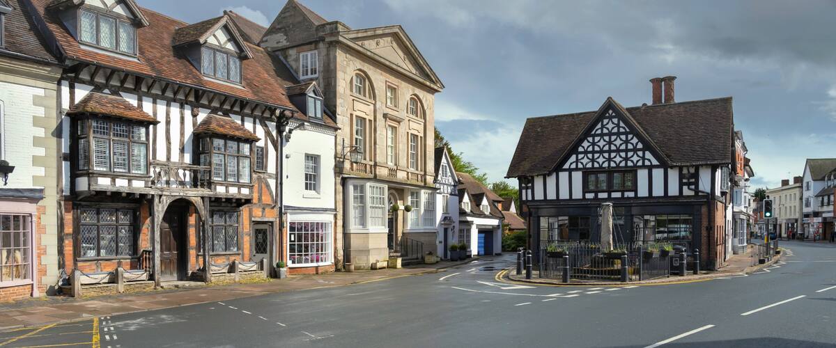 A street with historic half-timbered buildings and a clear sky.