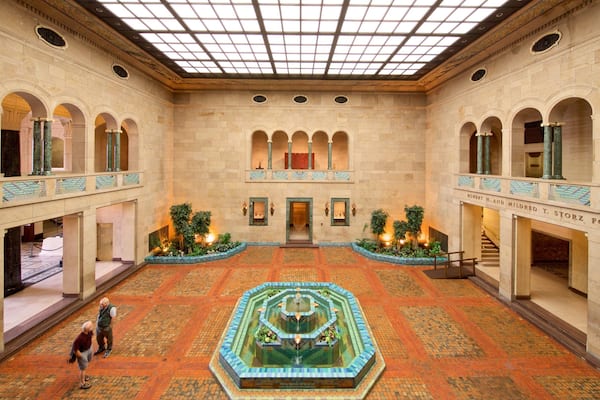 Un vaste atrium doté d’une fontaine centrale, d’arcades et d’un sol carrelé.