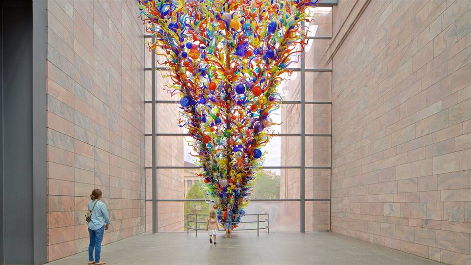 A large glass sculpture in a modern building with tiled walls and large windows.