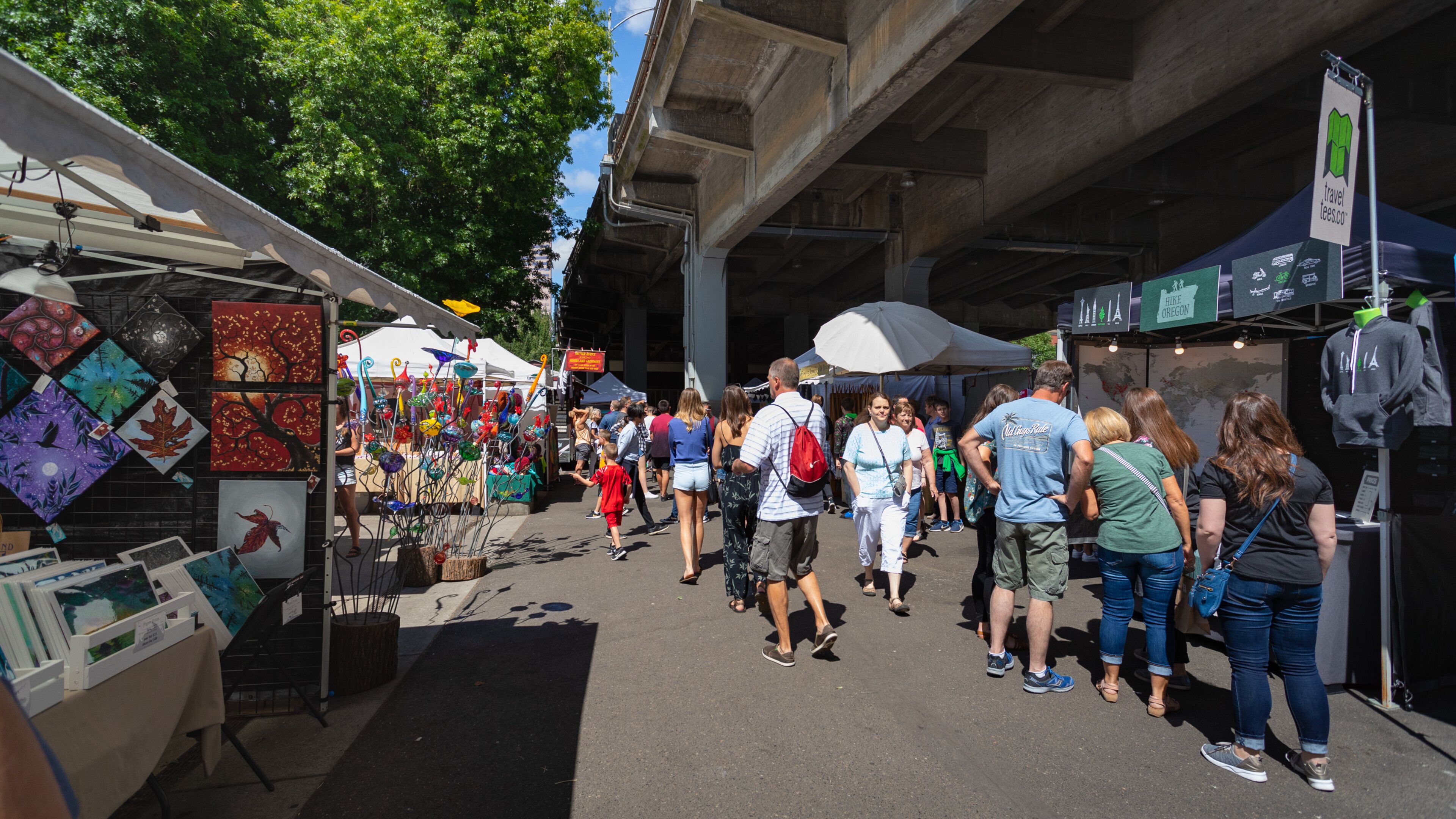 Portland Saturday Market showing markets as well as a small group of people