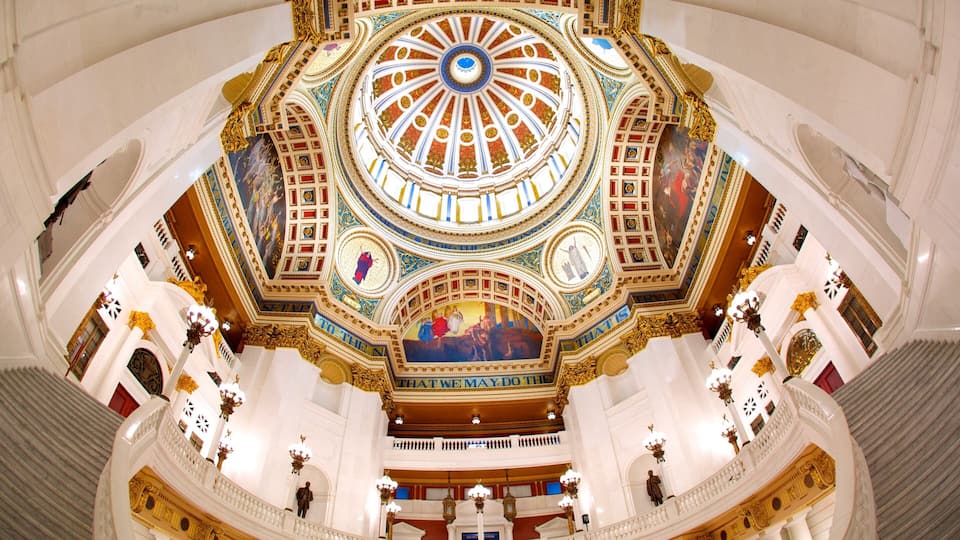 A grand, ornately decorated interior with a large central dome, intricate ceiling artwork, and classical architectural elements.