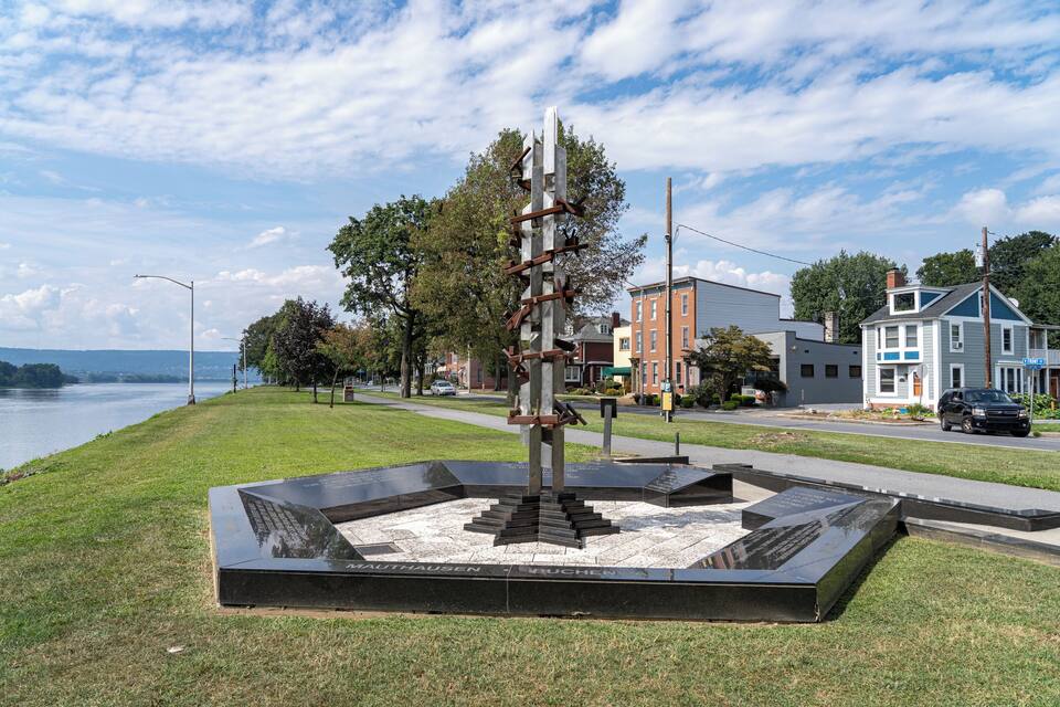 Une sculpture dans un parc, avec un lac en arrière-plan.
