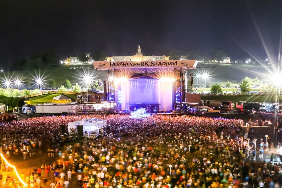 Lo stadio di Hersheypark di notte, con una grande folla radunata di fronte.