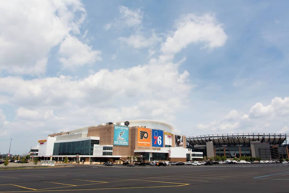 Um grande estádio esportivo com vários banners e anúncios, incluindo um para os Philadelphia Flyers.