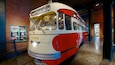 A vintage red and white bus with the number 1724, labeled 'Pittsburgh', displayed indoors.