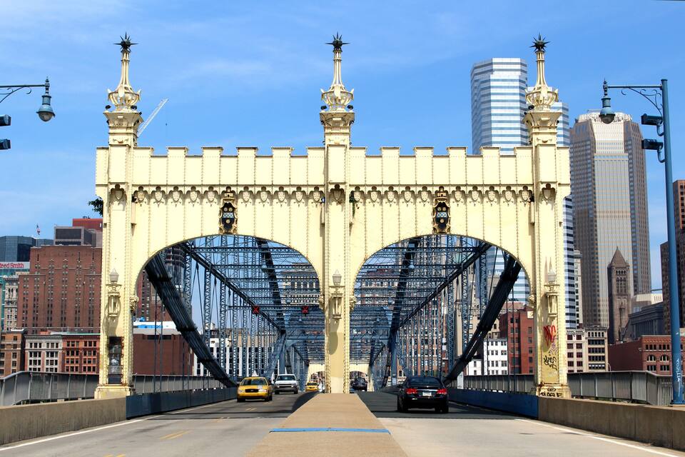 Un puente con torres ornamentadas y un paisaje urbano al fondo.