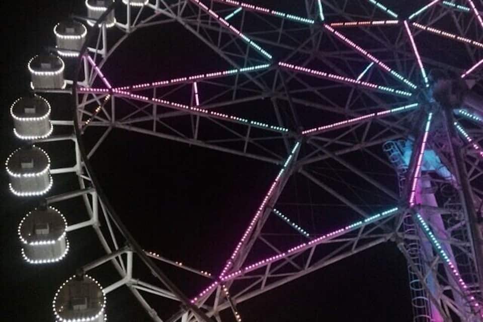 A Ferris wheel with colorful lights at night.