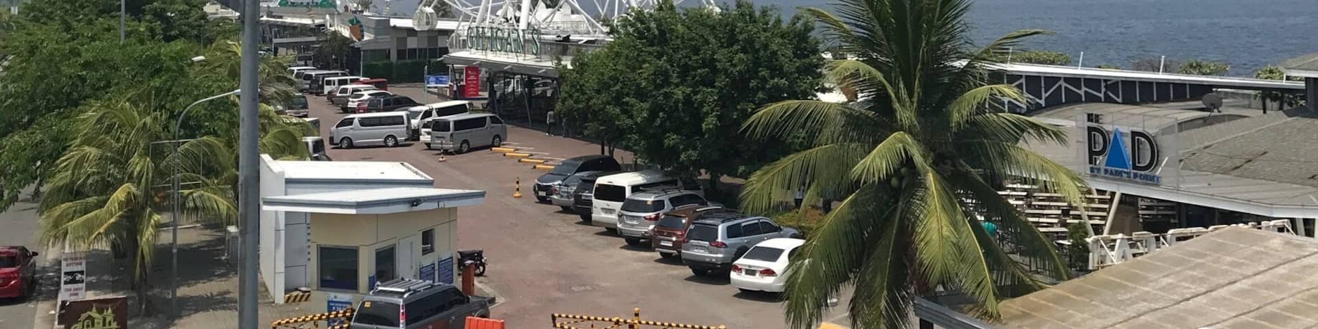 A Ferris wheel, parked cars, and a building with 'PAD' on it.