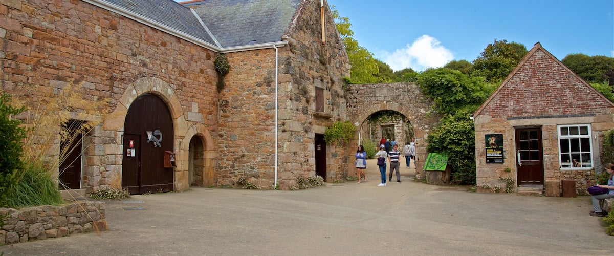 A historic stone building with arched doorways and a flagpole.