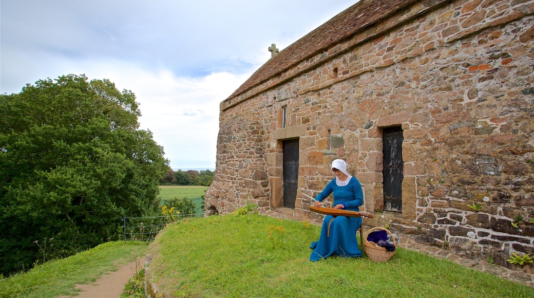 La Hougue Bie que inclui uma casa e elementos de patrimônio assim como uma mulher sozinha