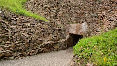 A stone wall with a large boulder protruding from it.