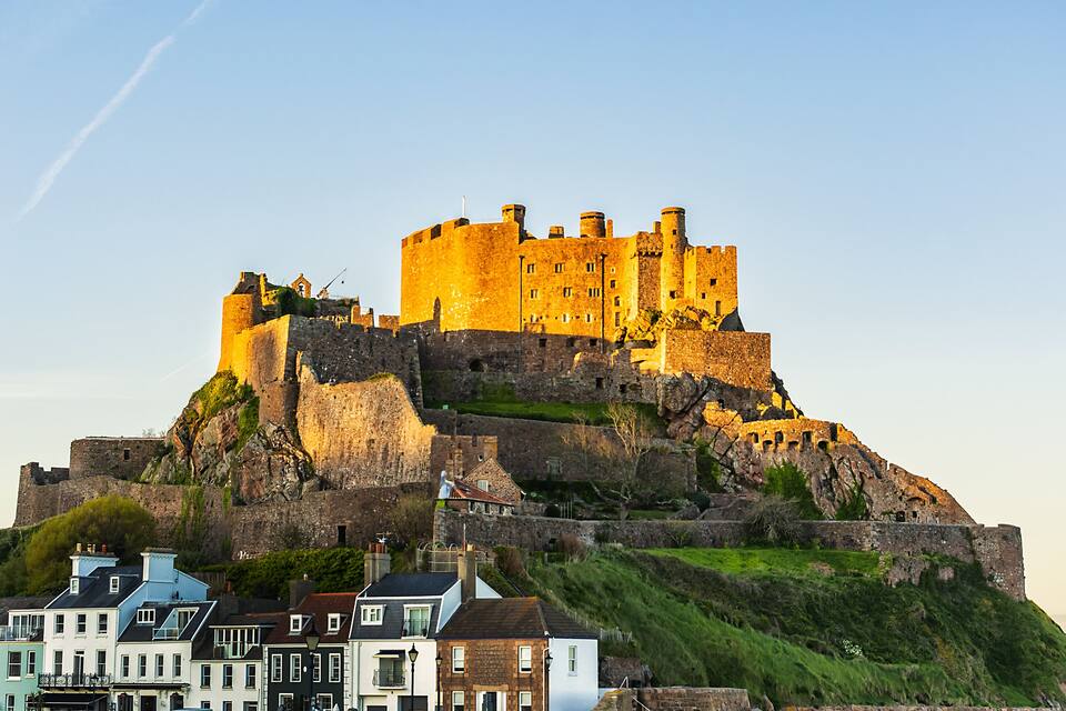 A historic castle on a hill with surrounding residential buildings.