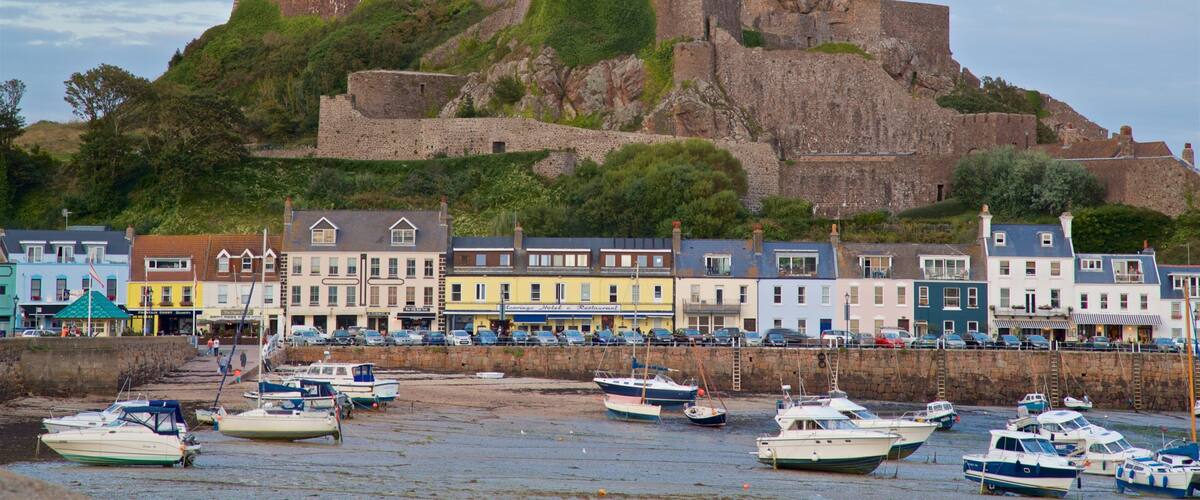 A historic castle on a hill with colorful buildings in the foreground.