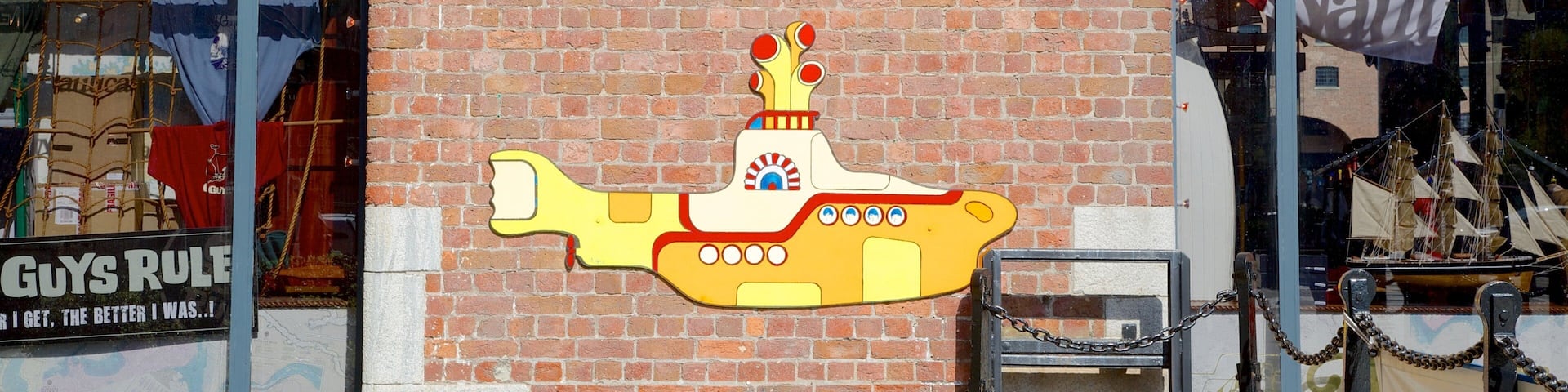 A brick building with a Beatles Story Exhibition sign and a submarine illustration.