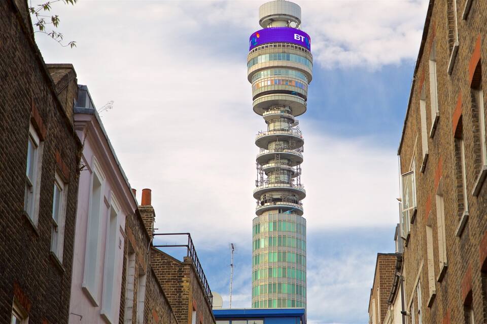 Torre da BT numa rua estreita ladeada por edifícios de tijolo.