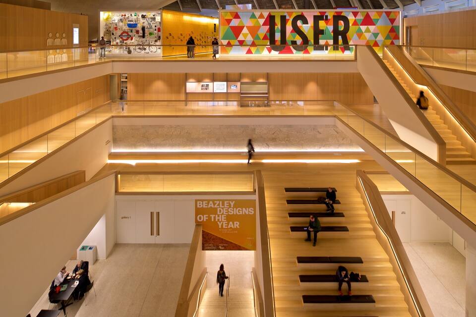 Um interior moderno com um grande letreiro 'USER', vários níveis e uma exposição 'BEAZLEY DESIGNS OF THE YEAR'.