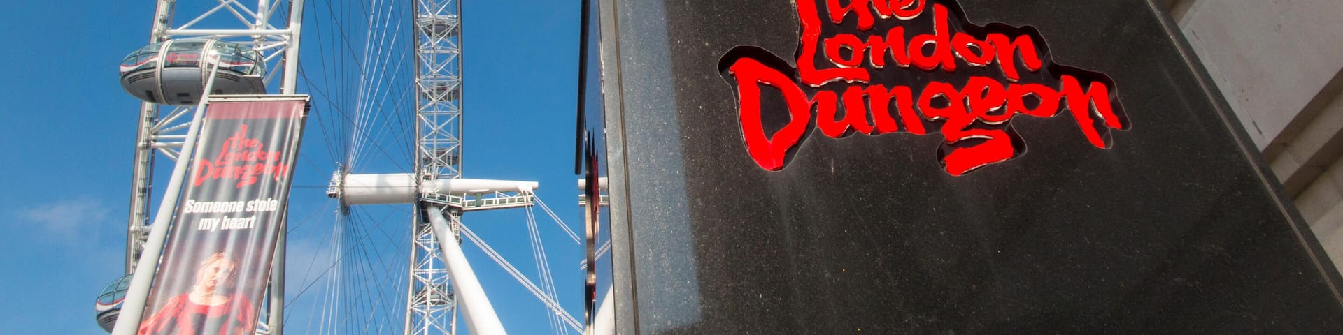 The London Dungeon sign and a Ferris wheel.